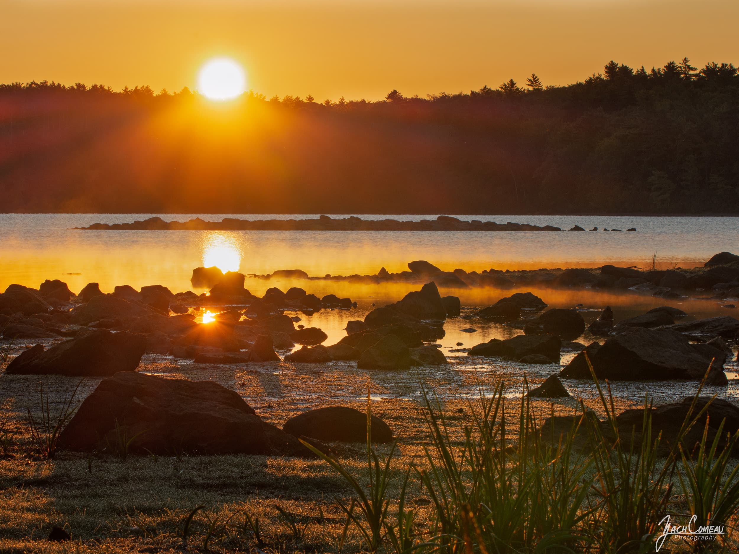 A glowing yellow sunrise over a lake in Fitchburg